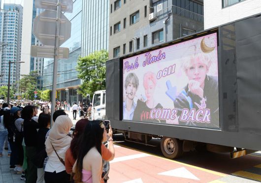 11일 방탄소년단(BTS)의 지민과 정국이 군 복무를 마치고 만기 전역했다. 서울 용산구 하이브 사옥에 방문한 지민과 정국의 모습을 보기 위해 모인 글로벌 아미들 사이로 지민의 영상 차량이 지나가고 있다. 김용학 기자