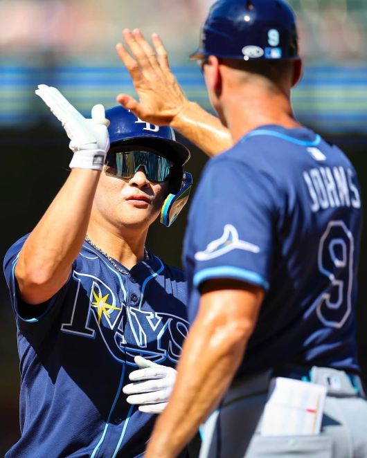 탬파베이 레이스의 김하성(왼쪽)이 안타를 치고 주루코치와 하이파이브를 나누고 있다. 사진=탬파베이 레이스 공식 SNS