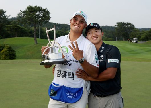 황경식 캐디(왼쪽)가 지난해 6월 KPGA 투어 백송홀딩스-아시아드CC 부산오픈에서 정상에 오른 김홍택과 기념사진을 찍고 있다. KPGA제공