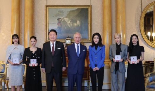 영국을 국빈 방문한 윤석열 대통령과 김건희 여사가 22일(현지시간) 런던 버킹엄궁에서 열린 문화 예술인 격려행사에서 찰스 3세 영국 국왕으로부터 대영제국훈장을 받은 블랙핑크 멤버들과 기념 촬영을 하고 있다. 왼쪽 부터 리사, 제니, 윤 대통령, 찰스 3세, 김 여사, 로제, 지수. /연합뉴스