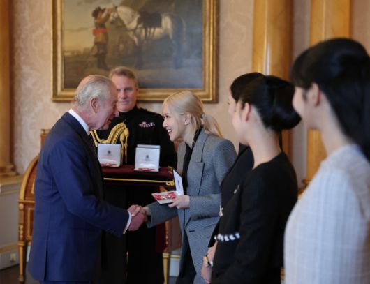 블랙핑크 로제가 22일(현지시간) 런던 버킹엄궁에서 열린 문화 예술인 격려행사에서 찰스 3세 영국 국왕으로부터 대영제국훈장을 받고 있다./연합뉴스