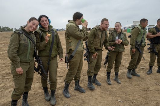 이스라엘 방위군(IDF) 155mm 자주곡사포 기지 병사들이 5일(현지시간) 팔레스타인 가자지구 경계 인근에서 간식을 먹고 있다./UPI·연합뉴스