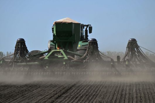 우크라이나 농부가 18일(현지시간) 우크라이나 키이우 지역의 들판에서 파종기가 달린 트랙터를 운전하면서 아마를 파종하고 있다./AFP·연합