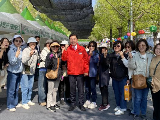 전진선 양평군수가 25일 오전 9시 30분쯤 의왕시에서 단체로 축제장을 찾은 관광객들과 함께 기념 촬영을 하고 있다./장은기 기자