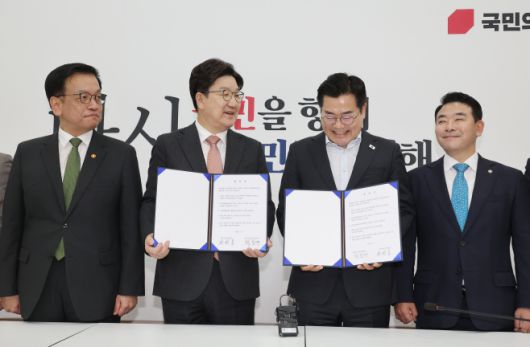 1일 서울 여의도 국회에서 더불어민주당 박찬대 당대표 직무대행 겸 원내대표와 국민의힘 권성동 원내대표가 추경안 합의문에 서명한 뒤 미소짓고 있다. /연합