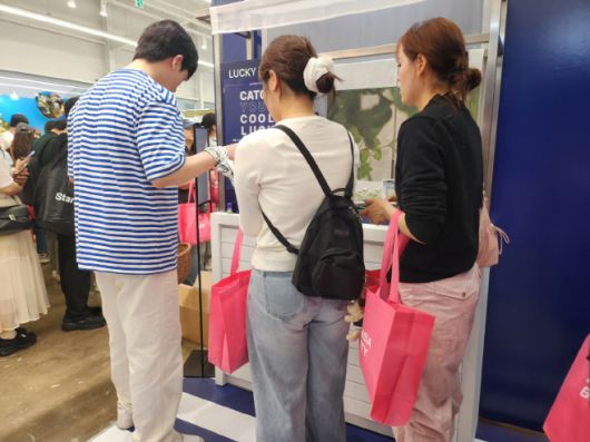 방문객이 게임에 참여한 뒤 브랜드가 준 사은품을 받아가고 있다./장지영 기자