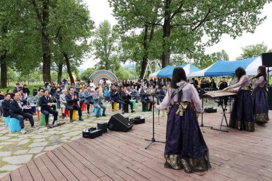 서태원 군수(좌측 4번째)와 김경수 군의회 의장(군수 옆)이 24일 '자라섬 꽃 페스타' 개막식 공연에서 박수를 치고 있다./가평군