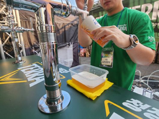 스태프가 켈리의 '변온 컵'에 생맥주를 따라주고 있는 모습. 맥주가 채워지면서 변온 알루컵의 색깔도 변하고 있다./장지영 기자