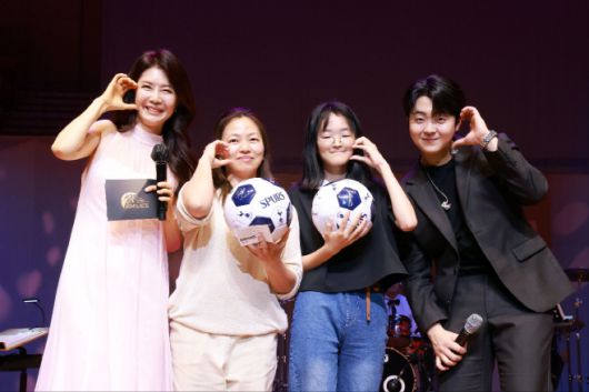 김숙진 대표(왼쪽)가 손홍민 선수 사인 축구공을 전달한 후 기념촬영을 하고 있다./ 킴스에이스 제공