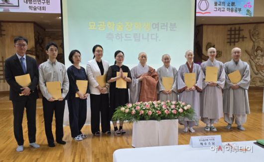 한마음선원 안양본원 주지 혜솔스님(가운데 가사를 수한 스님)과 묘공학술장학생 장학증서 수상자들./사진=황의중 기자