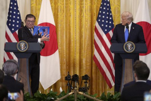 이시바 시게루(石破茂) 일본 총리(왼쪽)가 2월 7일(현지시간) 미국 백악관에서 가진 공동 기자회견에서 도널드 트럼프 미국 대통령이 선물한 책을 들어보이고 있다./AP·연합뉴스