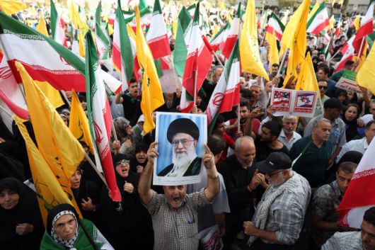 이란 시민들이 24일(현지시간) 이란 테헤란에서  최고지도자(아야톨라) 알리 하메네이 사진과 국기 등을 들고 시위를 벌이고 있다./EPA·연합