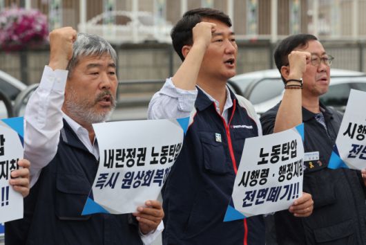 6월 25일 서울 용산구 대통령실 앞에서 열린 '위법한 시행령·행정지침 원상회복 요구 양대노총 기자회견'에서 양경수 민주노총 위원장(가운데)과 김동명 한국노총 위원장(왼쪽) 등의 참가자들이 구호를 외치고 있다. /연합뉴스