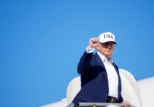 도널드 트럼프 미국 대통령(왼쪽)이 6일(현지시간) 뉴저지주 모리스타운에서 백악관으로 돌아오는 전용기 '에어포스원'에 탑승하면서 주먹을 들어보이고 있다./로이터·연합