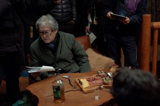 박찬욱 감독이 '어쩔수가없디' 촬영장에서 현장 대분을 확인하고 있다./제공=CJ ENM