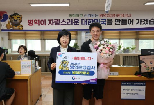 홍소영 병무청장이 15일 서울 영등포구 서울지방병무청에서 열린 2026년 첫 번째 병역판정검사 현장을 방문해 첫 현역판정자 우찬욱군에게 꽃다발을 전달하고 기념촬영하고 있다. /병무청