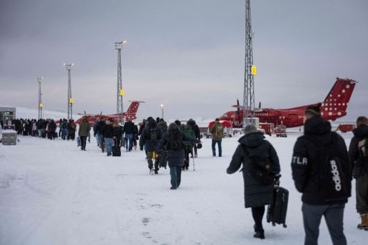 승객들이 19일(현지시간) 덴마크 코펜하겐에 도착한 에어그린란드에서 내려 활주로를 끌어가고 있다./AFP·연합