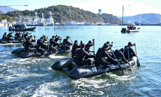 22일 경남 창원 진해군항에서 열린 혹한기 내한훈련에서 해군 해난구조전대(SSU) 대원들이 고무보트를 타고 철인중대 선발경기를 펼치고 있다. /해군
