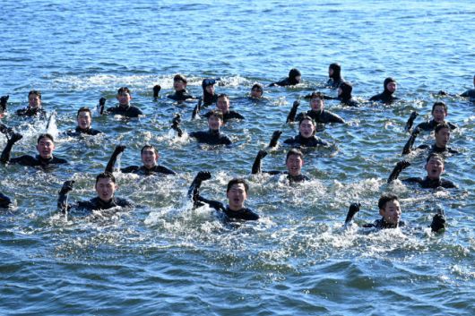 22일 경남 창원 진해군항에서 진행된 혹한기 내한훈련에서 해군 해난구조전대(SSU) 대원들이 바다에 떠오른 채 군가를 제창하고 있다. /해군