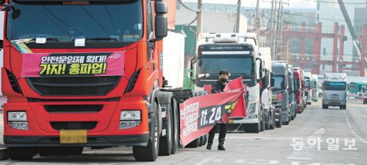 파업 플래카드 철거 9일 화물연대 조합원이 경기 의왕시 내륙컨테이너기지(ICD) 인근에 주차된 화물차에 붙어 있던  파업 관련 플래카드를 걷어내고 있다. 화물연대는 총파업 16일째인 이날 조합원 61.84%의 동의로 이번 파업을 종료했다.  의왕=홍진환 기자 jean@donga.com