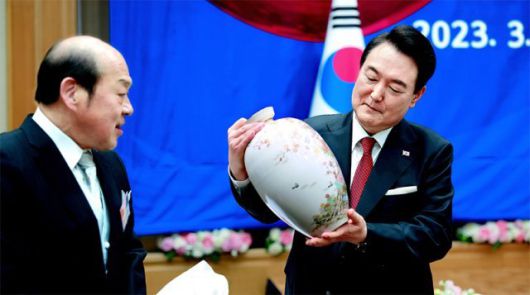 ‘심수관’ 도자기 선물받아 윤석열 대통령이 16일 일본 도쿄의 한 호텔에서 열린 재일동포 오찬간담회에서 조선 도공의 후예이자 일본 도자기 명가 ‘심수관  가’의 제15대 심수관(본명 오사코 가즈데루·왼쪽) 씨가 선물한 도자기를 살펴보고 있다. 대통령실은 이 도자기를 용산 대통령실  청사 로비에 전시하는 방안을 검토 중이다. 심 씨는 지난해 윤 대통령 취임식에도 참석한 바 있다. 대통령실 제공