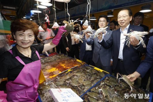 해수부장관, 인천어시장에 수산물 소비 활성화 현장점검을 위해 25일 인천 중구 인천종합어시장을 찾은 조승환 해양수산부  장관(오른쪽)이 시장 상인과 함께 꽃게를 손에 들고 있다. 국민의힘도 이날 서울 송파구 수협중앙회 본사를 찾아 수산물 안전 대책  마련을 강조했다. 인천=김동주 기자 zoo@donga.com