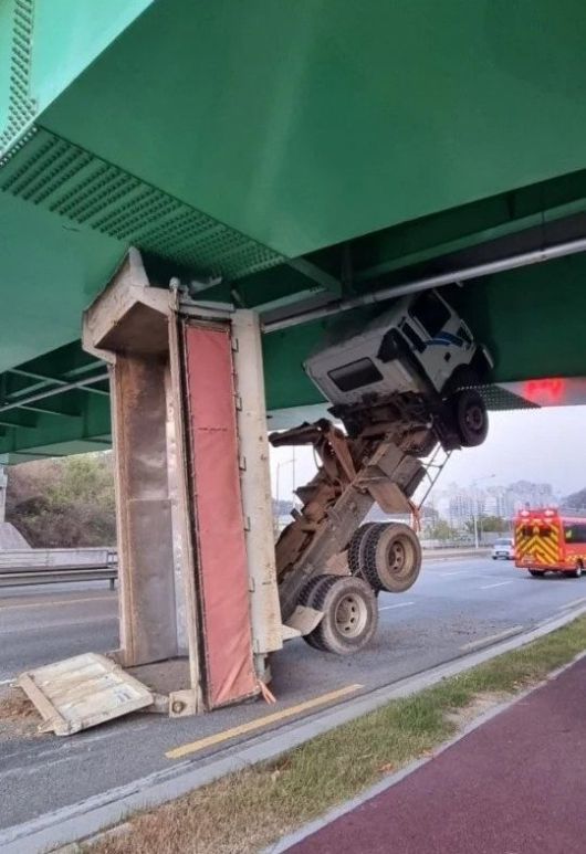 지난 23일 경북 구미의 한 도로에서 달리던 덤프트럭이 교량 밑에 끼이는 사고가 발생했다. 온라인 커뮤니티 캡처