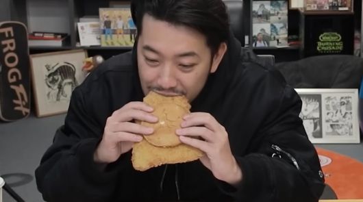 유튜브 채널 ‘침착맨’에서 만화가이자 유튜버인 이병건 씨가 ‘왕돈까스 버거’를 먹는 모습.