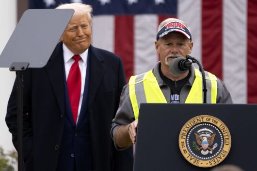 트럼프 대통령이 웃으며 미시간주의 자동차 노동자 출신 은퇴자 브라이언 페네베커(오른쪽)의 연설을 듣고 있다. 워싱턴=AP 뉴시스