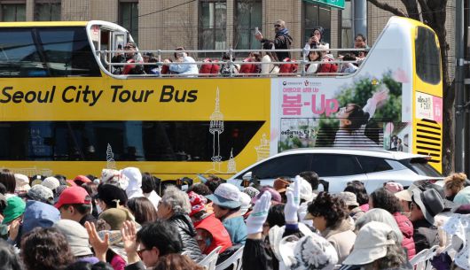 6일 오전 서울 종로구 세종대로 동화면세점~코리아나호텔 앞 편도 전 차로에서 사랑제일교회의 전국 주일 연합 예배가 진행되고 있는 가운데 서울 시티투어 버스에 탑승한 관광객이 예배 광경을 촬영하고 있다. 2025.04.06. [서울=뉴시스]