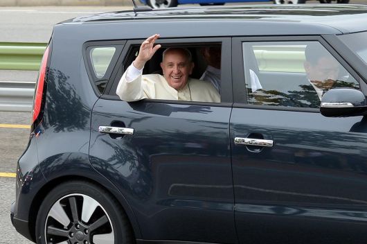 한국을 방문한 프란치스코 교황이 14일 오전 경기 성남시 수정구 서울공항을 나서며 기아 쏘울에 탑승해 환영객들에게 손흔들고 있다. 프란치스코 교황은 취임 초기부터 방탄차를 이용하지 않겠다고 공언했으며, 실제 한국 방문 때도 가장 작은 차를 타고 싶다는 뜻을 한국 천주교 교황방한준비위원회에 전달해온 것으로 알려졌다. 이에 따라 방한 기간 중 교황은 기아자동차의 1600cc급 소형 승용차인 쏘울을 탔다. 2014.8.14/뉴스1