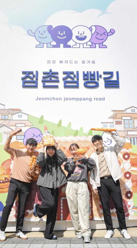 23일 경북 문경시 점촌점빵길 포토존에서 ‘제1회 점촌점빵길 축제’ 홍보에 나선 지역 청년들이 빵을 들고 미소짓고 있다. 문경시 제공