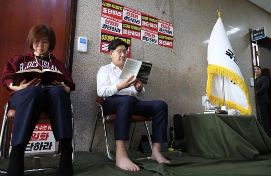 당 대선 후보 단일화 등을 촉구하며 단식 농성에 돌입한 권성동 국민의힘 원내대표와 김미애 의원이 8일 오전 서울 여의도 국회 원내대표실 앞에서 책을 읽고 있다.뉴시스