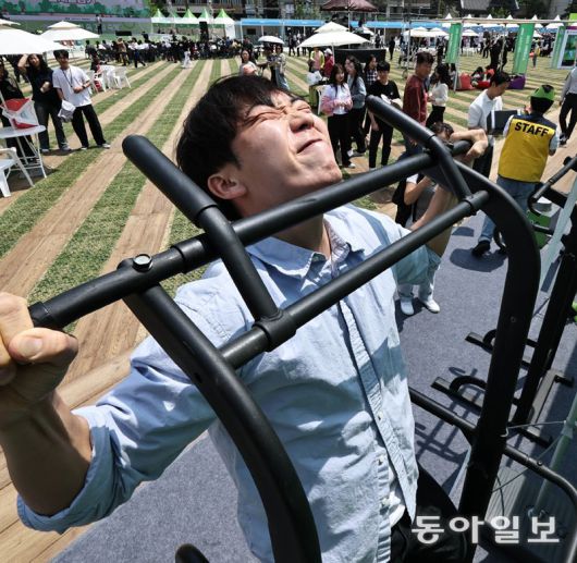 한 시민이 서울헬스쇼 행사로 마련된 턱걸이 이벤트에 참가해 턱걸이를 하고 있다. 송은석 silverstone@donga.com·변영욱 기자