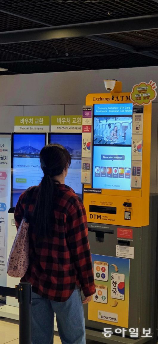 한 중국인 관광객이 서울 용산구 N서울타워 전망대 입구에 비치된 ‘가상자산 현금자동인출기(ATM)’를 살펴보고 있다. 여기서 외국인 관광객들은 법정화폐뿐 아니라 비트코인, 이더리움, 테더를 원화로 환전할 수 있다. 강우석 기자 wskang@donga.com