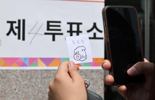 제21대 대통령 선거일인 3일 서울 서대문구 서울창서초등학교에 마련된 신천동 제5투표소를 찾은 유권자가 투표를 마친 후 인증샷을 찍고 있다. 2025.6.3/뉴스1