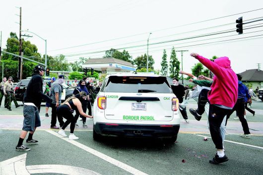 7일(현지 시간) 일부 시위대는 ICE 차량을 발로 차며 당국에 항의 의사를 표했다. 로스앤젤레스=AP 뉴시스