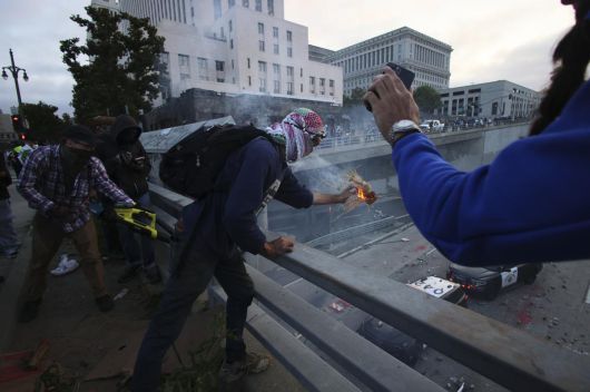 8일(현지시간) 미국 캘리포니아주 로스앤젤레스 도심 메트로폴리탄 구치소 인근 프리웨이에서 시위대가 경찰 차량을 향해 물체를 던지고 있다. AP 뉴시스