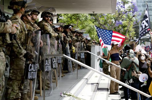 14일 캘리포니아주 로스앤젤레스 시내의 한 연방정부 건물 앞에서 ‘노 킹스’ 시위가 열렸다. 건물 입구를 봉쇄한 주방위군 앞에서 시위하는 시민들. 로스앤젤레스=AP 뉴시스