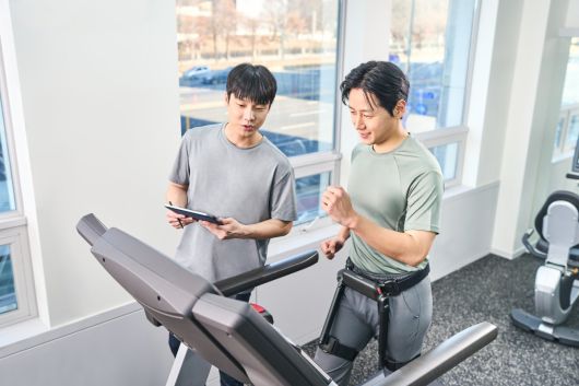 윔 S’를 착용한 사용자가 트레드밀에서 보행 운동을 실시하며 실시간으로 운동 효과를 확인하고 있다.