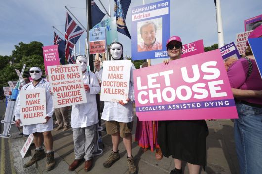 영국 하원에서 20일(현지 시간) 안락사를 허용하는 법안에 대한 투표가 진행되는 동안 법안에 찬성하는 사람들과 반대하는 사람들이 각자의 주장이 담긴 손팻말을 들고 결과를 기다리고 있다.  AP=뉴시스