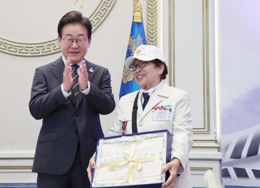 이재명 대통령이 27일 청와대 영빈관에서 열린 ‘호국보훈의 달, 대통령의 초대’ 행사에서 특별초청 대상자인 6·25전쟁 참전유공자 이춘자 참전용사에게 광목이불 선물을 전달 후 박수치고 있다. (대통령실통신사진기자단) 2025.06.27.