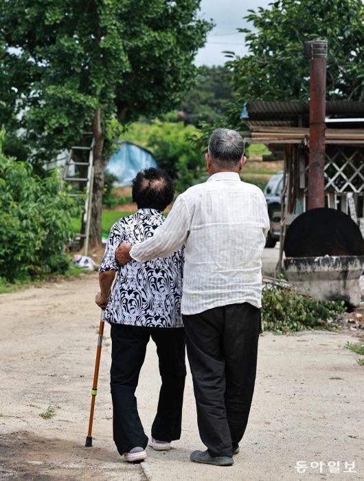 30일 오후 안무춘 씨(오른쪽)가 아내 김옥태 씨를 부축해 함께 동네를 산책하고 있다. 충남 서산시 해미면에 사는 안 씨 부부는 각각 2014년, 2015년 치매 진단을 받았다. 서산=양회성 기자 yohan@donga.com