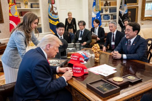 4월 16일(현지시간) 도널드 트럼프 미국 대통령이 워싱턴DC 백악관 집무실에서 아카자와 료세이 일본 경제재생상과 만나 관세 협상 전 자신의 ‘마가(MAGA, 미국을 다시 위대하게’ 모자에 서명하고 있다.  백악관