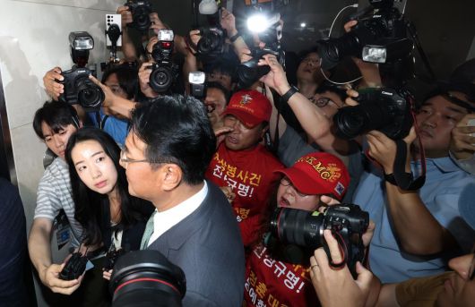 11일 피의자 신분으로 특검에 출석하는 김태효 전 국가안보실 1차장. 주변에서  해병대 예비역연대 회원이 항의를 보내고 있다. 뉴스1