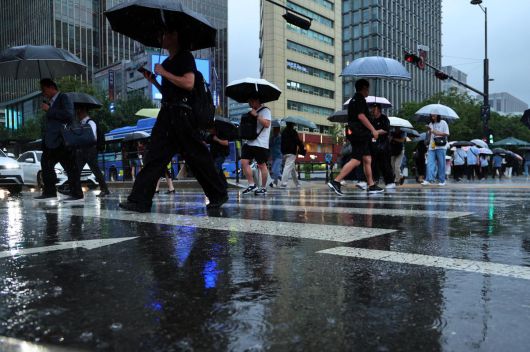 비가 내린 16일 오후 서울 종로구 광화문광장에서 우산을 쓴 시민들이 퇴근길 발걸음을 재촉하고 있다. 뉴스1