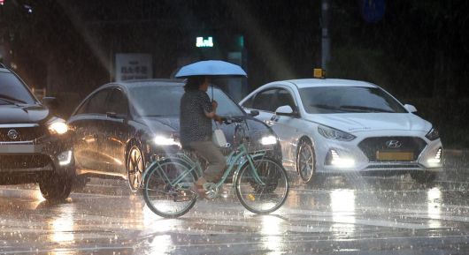 서울 전역에 호우주의보가 발효된 16일 서울 노원구 상계동 거리에서 시민이 내리는 비를 맞으며 횡단보도를 건너고 있다. 뉴시스