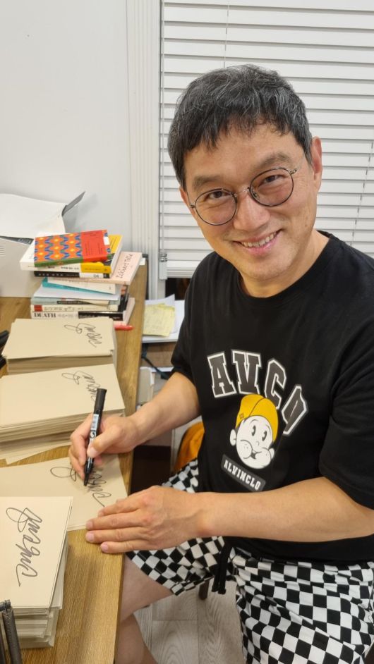 고명환 작가가 ‘고전이 답했다: 마땅히 가져야 할 부(富)에 대하여’에 사인하고 있다. 그는 1만 100권에 직접 사인해 전작 사인 기록(1만 권)을 깼다. 라곰 제공