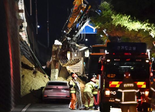 수도권 등 중부지역에 호우주의보가 발효된 16일 오후 경기 오산시 가장교차로 고가도로 옹벽이 무너져 소방관들이 매몰된 차량을 구조작업하고 있다. 2025.07.16 뉴시스