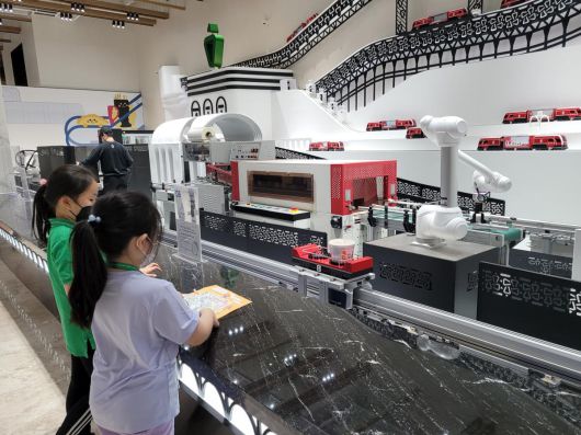 대구 북구의 세계 최초 떡볶이 박물관인 신전뮤지엄을 찾은 어린이들이 로봇과 함께 자신만의 떡볶이 밀키트를 만들고 있다.